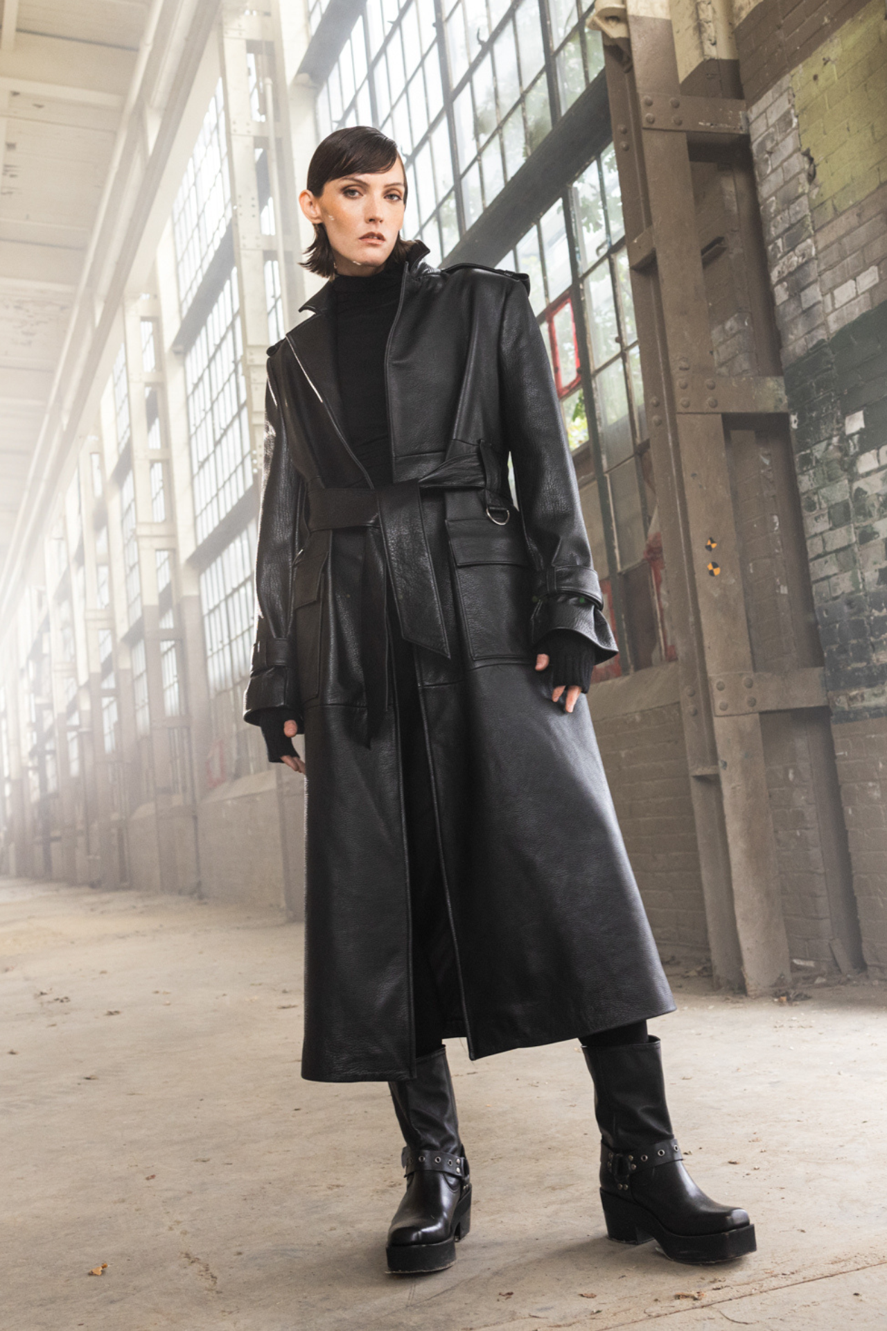 Discover the timeless versatility of our unisex pebbled leather trench coat, crafted for all seasons. With a regular shoulder and comfortable fit through shoulders and chest, it includes a tie belt at the waist and strap detailing on the cuff. The notch collar and patch pockets add classic elements, perfect for layering and making a stylish statement. Ideal for winter, this leather coat offers durability and timeless style, suitable for any occasion.