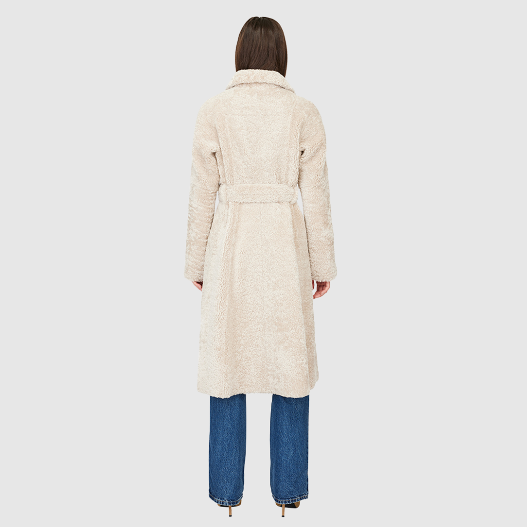 Knee length mouton teddy wool coat Fitted a-line silhouette Notch collar Center front three button closure with tie wrap Slash pockets Fully lined