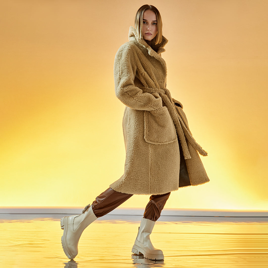 This elegant, reversible full-length shearling coat offers two beautiful styles in one. 51" long. It reverses from a beautiful nappa finish to a plush fur-out style and has two slip pockets.  Made from genuine Spanish merino shearling sheepskin. Double breasted. Slight dropped shoulder fits comfortably across the shoulders. Loose fit through the torso. 