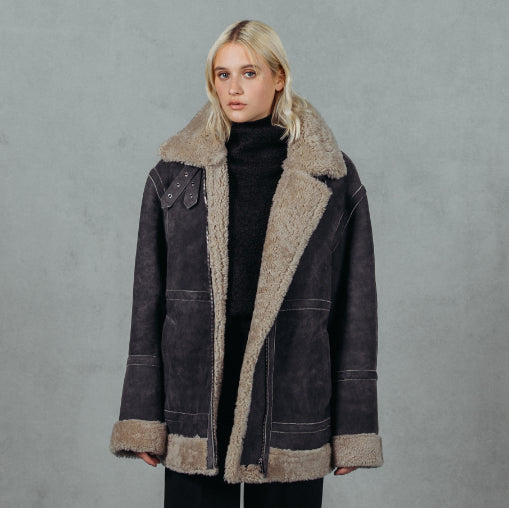Black Beige. Shearling. Reversible. Fits comfortably across the shoulders, loose-fit through the torso. Relaxed armholes. 32 inch length