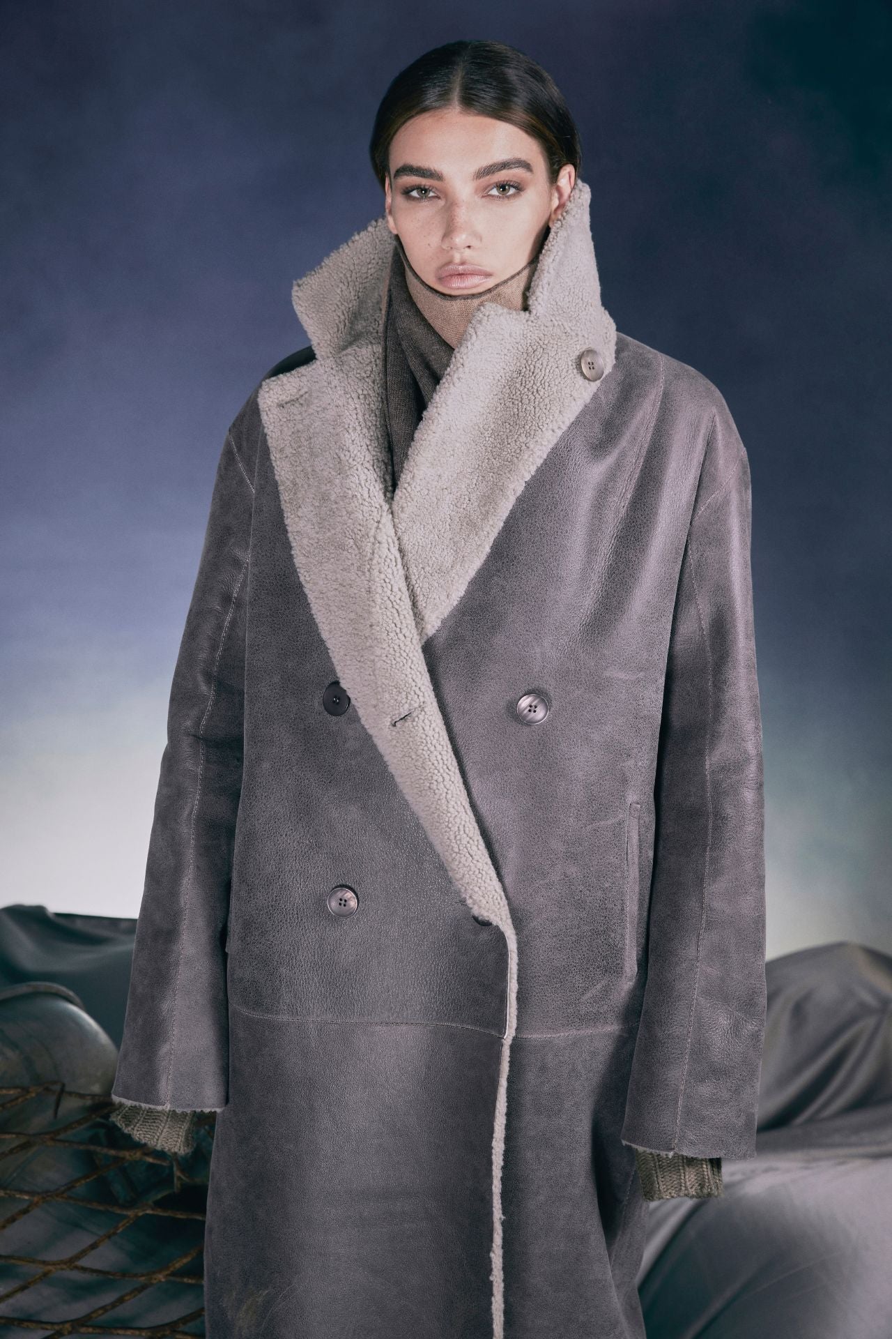 Reversible nappa loose fitting coat Reverses to curly wool teddy Slight drop shoulder Double breasted button closure