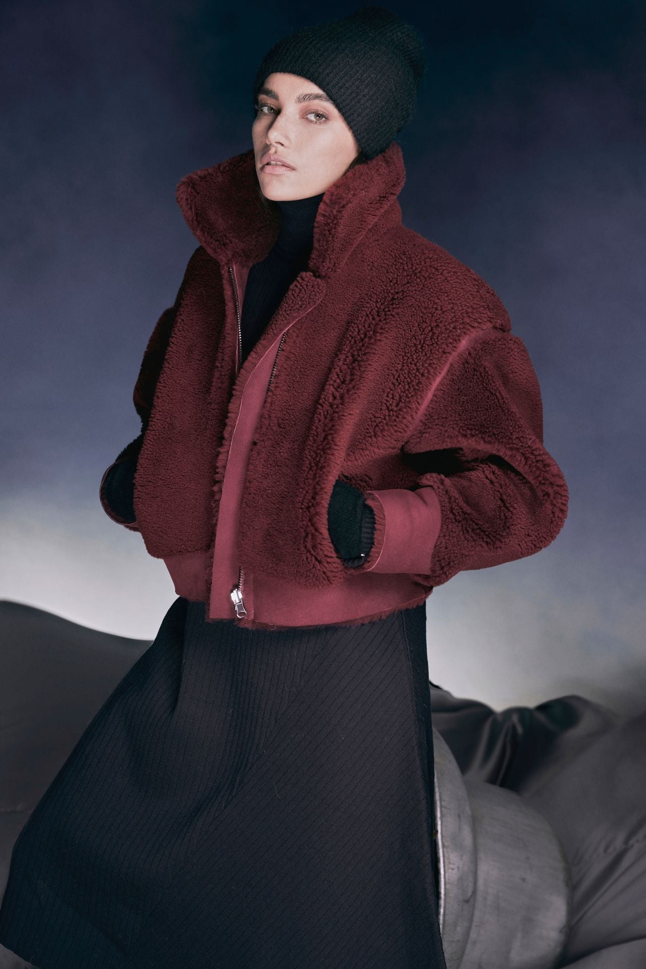 Introducing our Burgundy Suede Curly Wool Shearling Bomber Coatƒ??a versatile winter essential! Crafted from luxurious suede, this reversible coat keeps you cozy with its curly wool shearling lining. The ultralight 20-inch length ensures comfort without bulk, while the long sleeves and relaxed deep armholes allow easy movement. Pull-through pockets add practicality, and the raw edge finish adds a touch of rugged elegance. Perfect for chilly days and chic evenings!