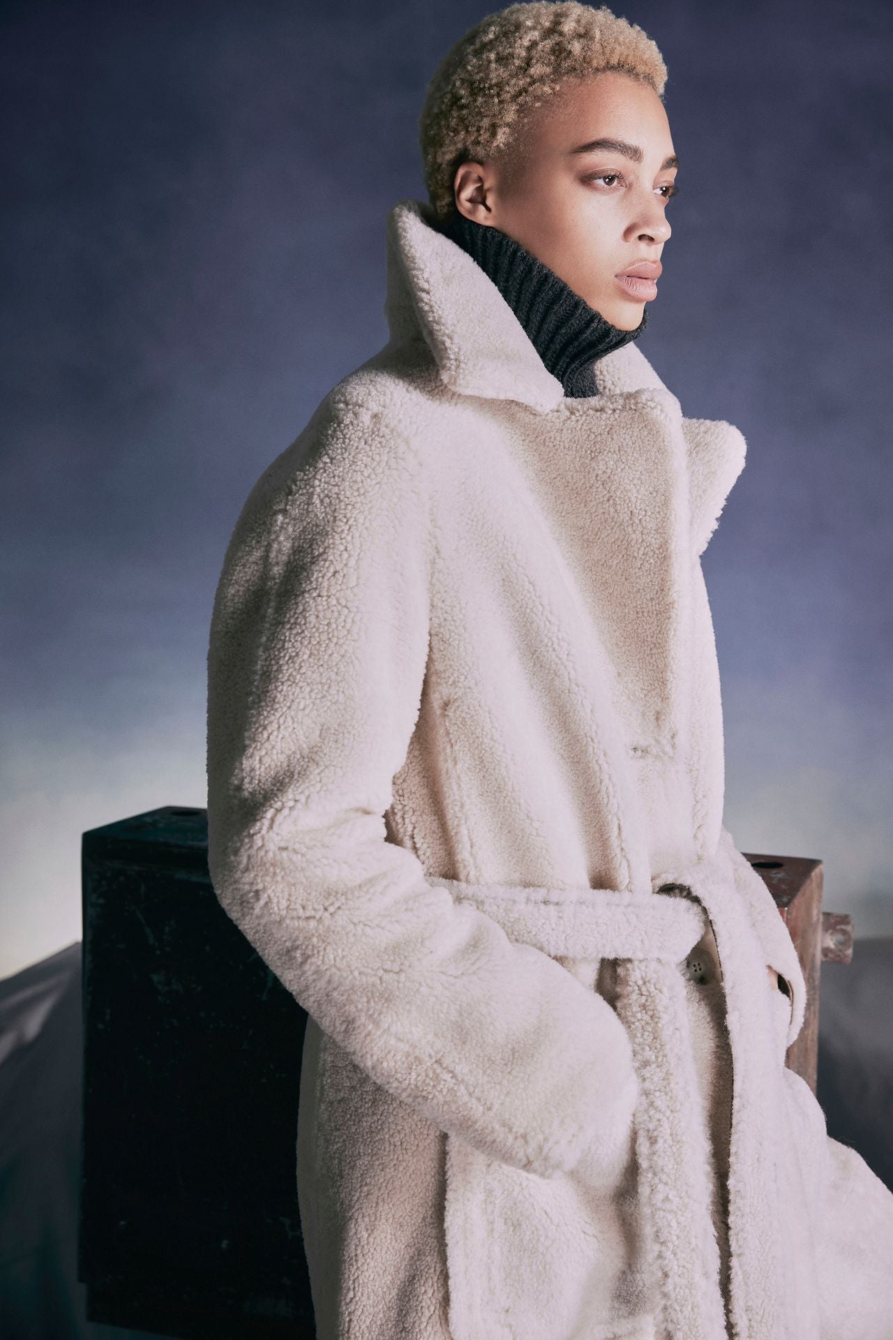 Vintage inspired reversible notch collar nappa coat Reverses to curly wool teddy Relaxed dropped shoulder 3 button closure Tie belt at waist Zip pockets on nappa side, reverses to patch pockets on teddy side